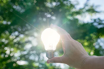 LED-Lampe Hand hält LED-Lampe gegen die Sonne