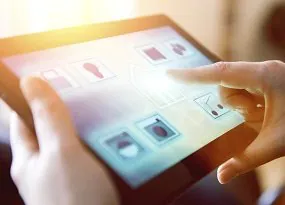 Die Beleuchtung einer Wohnanlage über ein Tablet. Person steuert die Beleuchtung einer Wohnanlage über ein Tablet.