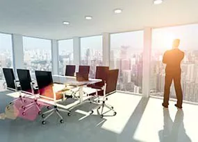 Mann steht in einem Büro und guckt aus dem Fenster Mann steht in einem Büro und guckt aus dem Fenster